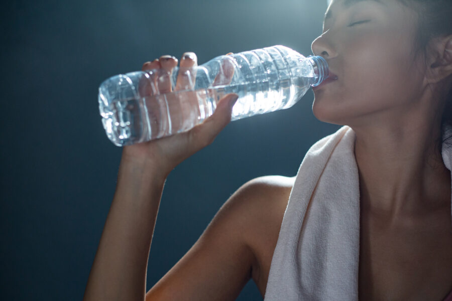 donna beve acqua durante allenamento